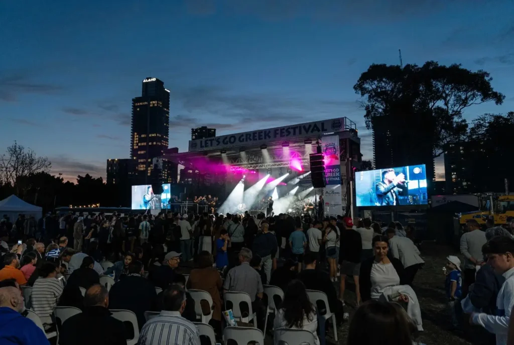Festival crowd under pink stage lights.