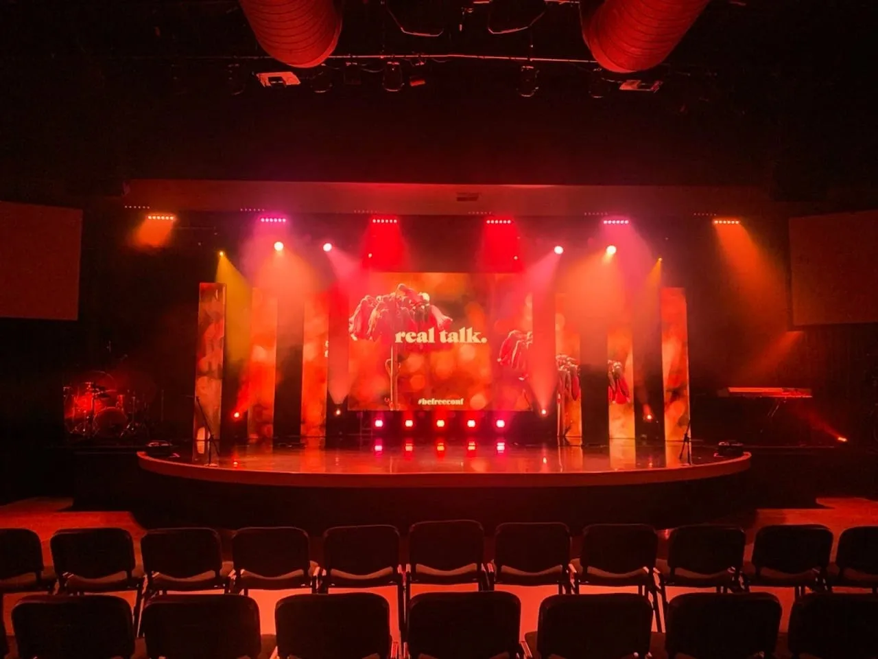 Professional theatre stage with red lighting and LED backdrop display