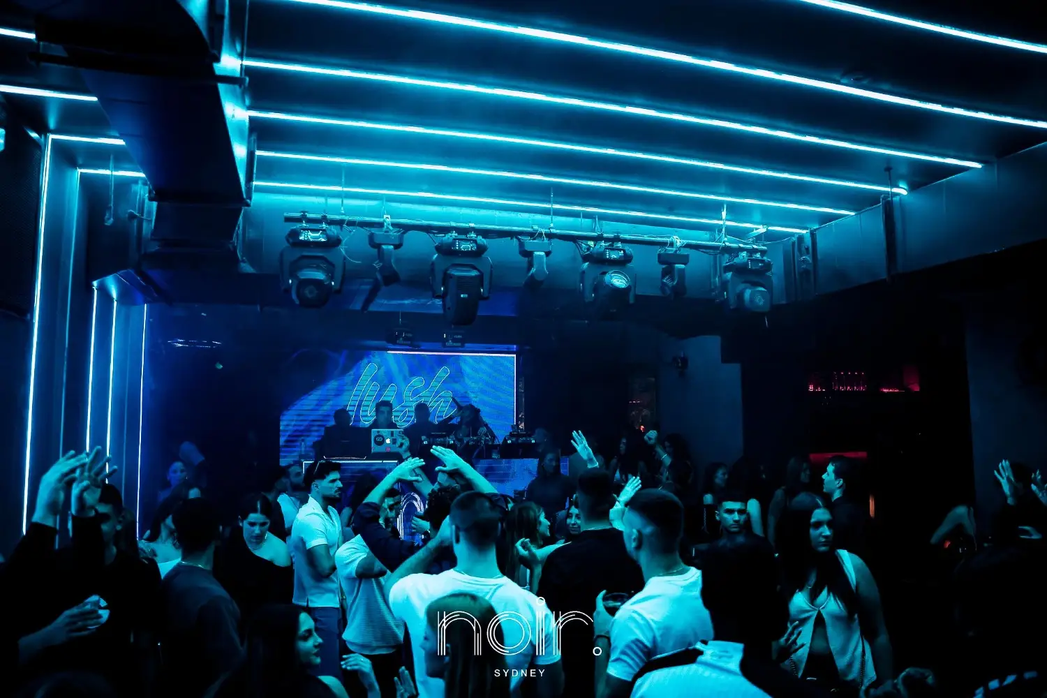 Club with blue lighting and DJ booth.