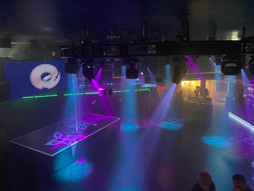 DJ booth with colorful lighting in nightclub.