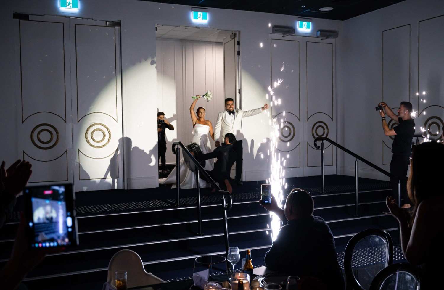 Wedding live streaming setup with guests celebrating and sparklers.